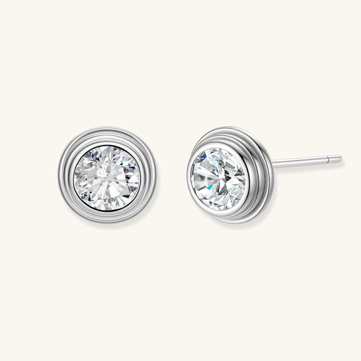 Close-up of sterling silver stud earrings featuring concentric circular frames with brilliant moissanite centers